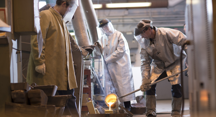 materials students and professor pouring a cast in the Metal Processing Lab